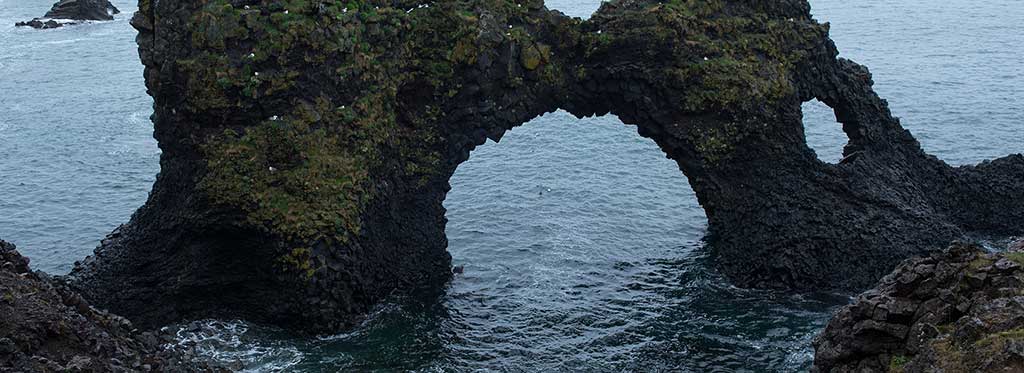 Rotsboog in zee met stromend water als symbool voor beweging en doorgang